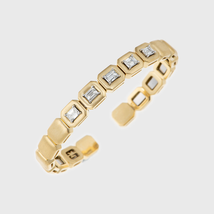 Yellow gold bangle bracelet with emerald cut white diamonds