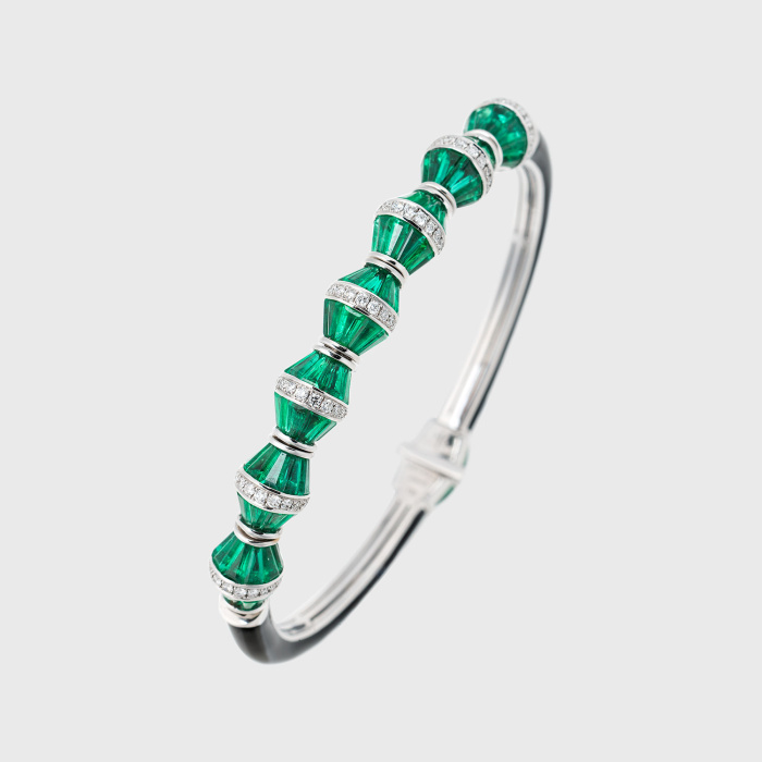 White gold tennis bracelet with tapered emerald baguettes, white diamonds and black enamel
